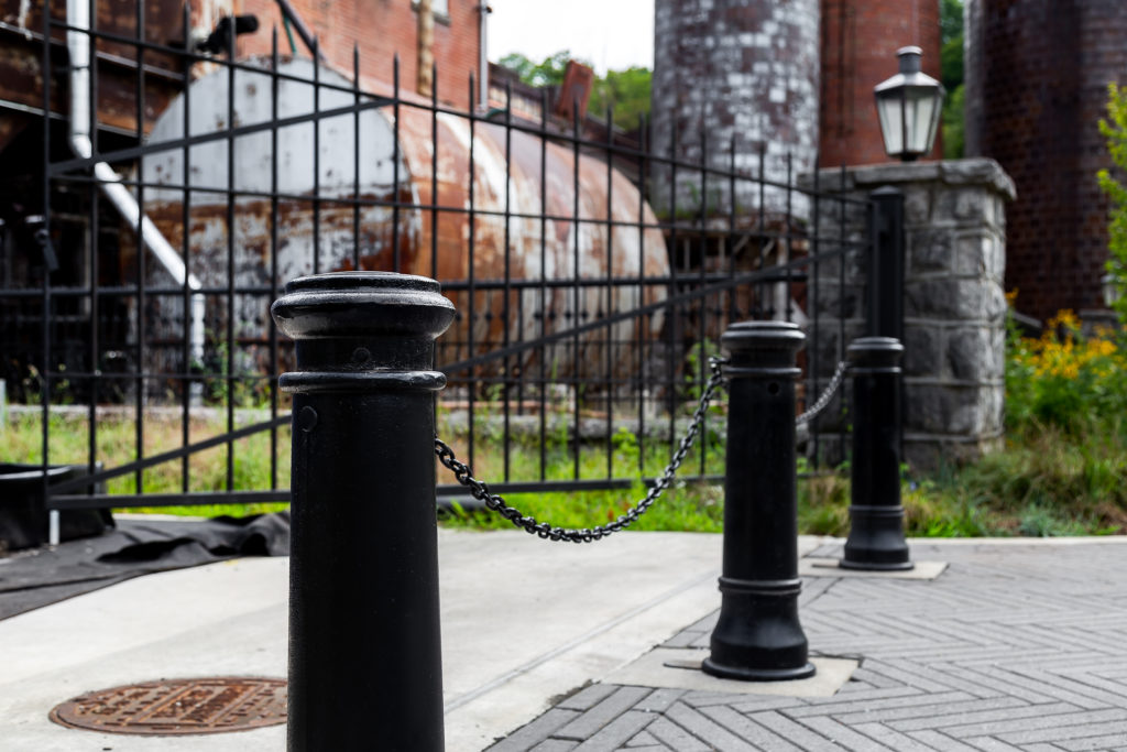 Black cast iron bollards with chain in front of gate
