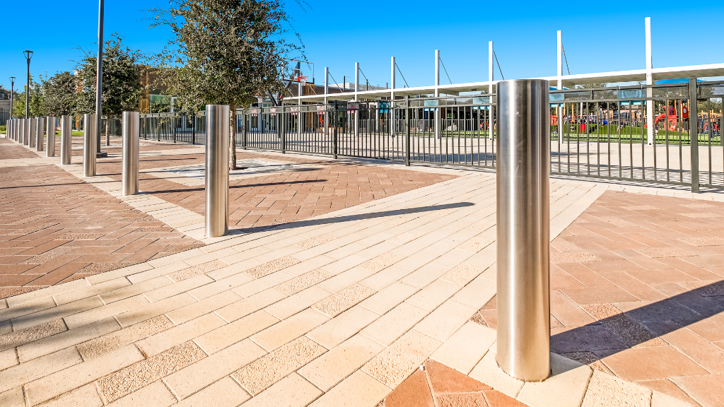 Stainless steel safety bollards on school grounds.