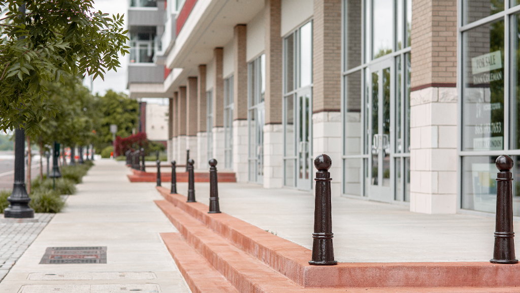 Cast iron bollards outside the entry of a mixed-use commercial and residential building.